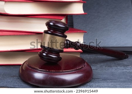 Law concept - Open law book with a wooden judges gavel on table in a courtroom or law enforcement office on blue background. Copy space for text Royalty-Free Stock Photo #2396915449