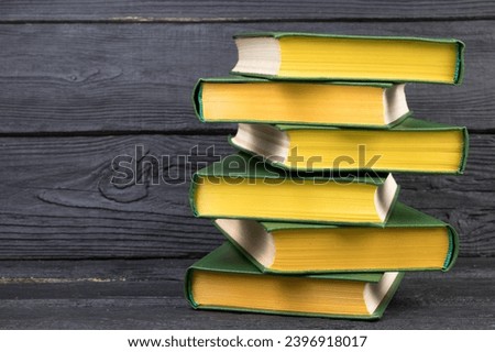 Books on wooden table, black board background. Back to school. Education business concept
