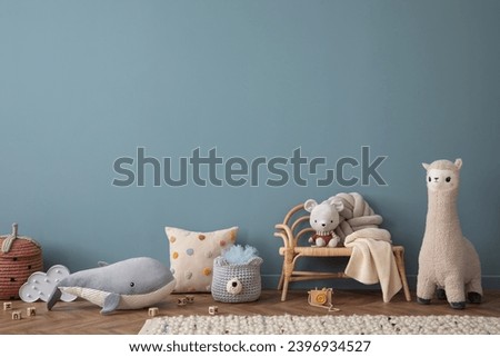 Warm and cozy living room interior with blue wall, rattan sideboard, stylish armchair, plush whale, mouse, toys, guitar, ornament on wall, braided rug and personal accessories. Home decor. Template.
