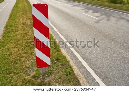 Red and white striped traffic sign on road as safety warning in summer Royalty-Free Stock Photo #2396934947