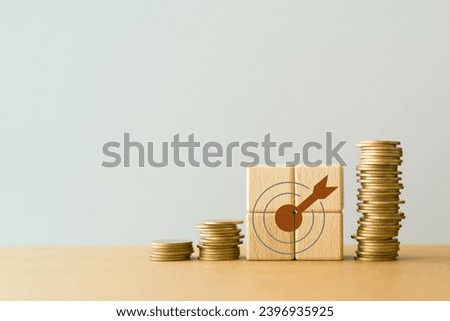dartboard icon on wooden cube block and stack of coins including copy space for financial concepts , financial investment business stock growth, profit, business strategy, business target.
