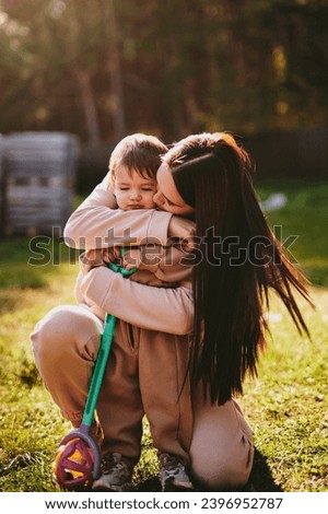 Portrait of young mother with her son. Happy motherhood, woman playing with boy on sunny autumn day
