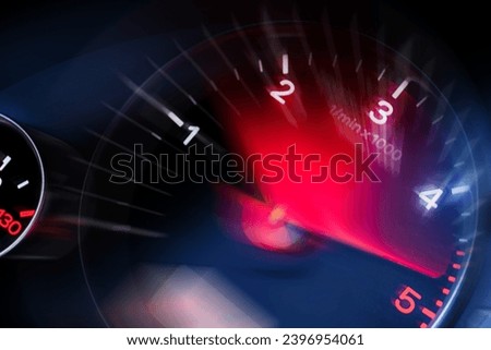 Motion blur of a car instrument panel dashboard odometer with red illuminated display.Car speedometer. High speed car speedometer and motion blur at night. Royalty-Free Stock Photo #2396954061