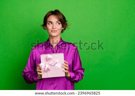 Photo of dreamy woman wear pink shirt hold wrapped package surprise box beauty products look novelty isolated on green color background