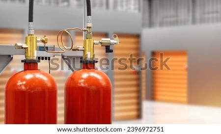 Fire extinguishing system in warehouse. Red balloons for automatic flame extinguishing. Fire extinguishers near blurred warehouse. Storage units are equipped with fire extinguishing system.  Royalty-Free Stock Photo #2396972751
