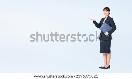 Guiding Asian woman wearing business suits with document file. Wide angle visual for banners or advertisements.