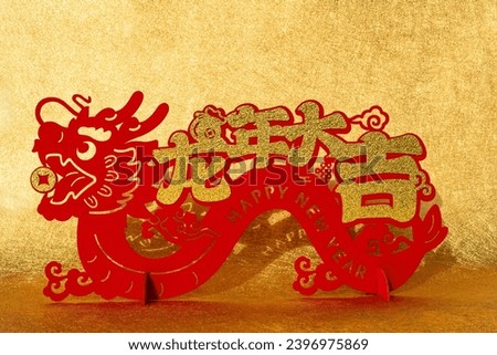 Chinese New Year of Dragon mascot paper cut on gold background English translation of the Chinese words are good luck in the year of dragon and no logo no trademark