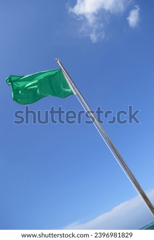 green flag on the beach, symbol for swimming allowed