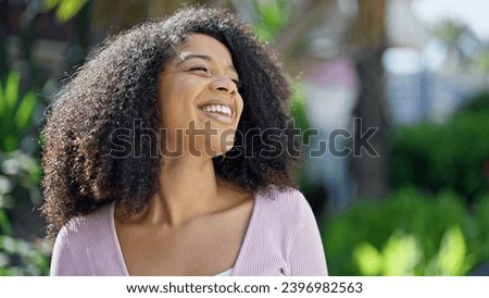 African american woman smiling confident looking to the side at park Royalty-Free Stock Photo #2396982563