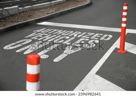 Sign Authorized Vehicles Only painted on asphalt outdoors
