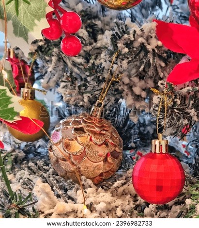 Picture of many types of Christmas ornament with red and gold balls, red cherry, green leaves and snow,  for indoor decoration