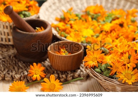 Many beautiful fresh calendula flowers on table