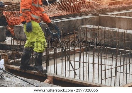 Concrete cast-in-place work. Builder level wet concrete. Concrete works on buildiiing construction site Royalty-Free Stock Photo #2397028055