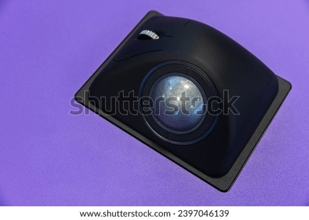 Built-in tabletop input device, black trackball mouse, a pointing device consisting of a ball held by a socket containing sensors to detect a rotation of the ball about two axes Royalty-Free Stock Photo #2397046139