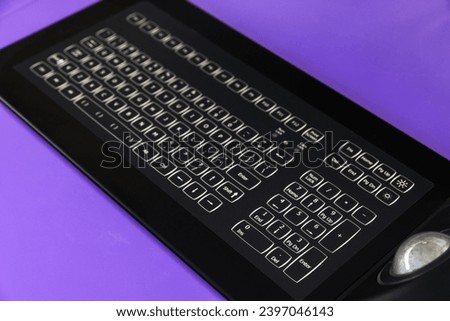 Built-in tabletop input device with black industrial keyboard with trackball mouse, modern navigation equipment mounted on a captains bridge  Royalty-Free Stock Photo #2397046143