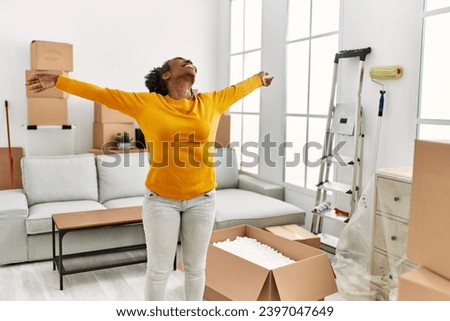 African american woman smiling confident standing with arms open at new home Royalty-Free Stock Photo #2397047649