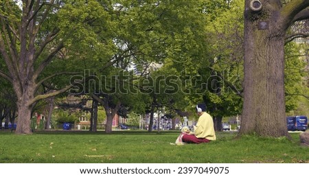 Girl with headphones, dog beside, reflecting healthy lifestyle in park setting. Symbolizing healthy lifestyle choices, they enjoy nature. Embracing healthy lifestyle, they relax outdoors.