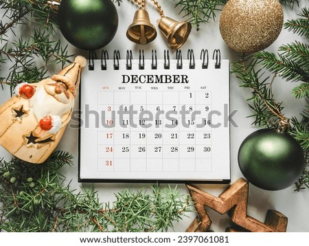 Merry Christmas. Happy New Year. Calendar and Christmas decorations lying on an empty table. Close-up, view from above. Congratulations for loved ones, relatives, friends, colleagues