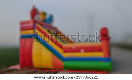 Soft focus Inflatable Bounce House against dark sky background.Big, colorful, inflatable castle labyrinth
