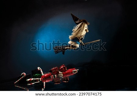 Italian Epiphany day tradition. Witch Befana flying on broomstick, moon light, Christmas sweets and sweet coal Royalty-Free Stock Photo #2397074175