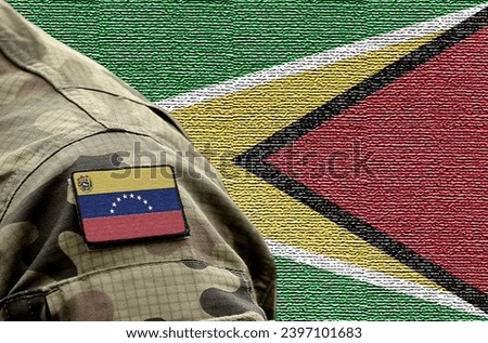 Flag of Venezuela on military uniform and flag of the Guyana at background. Venezuela VS Guyana. Royalty-Free Stock Photo #2397101683