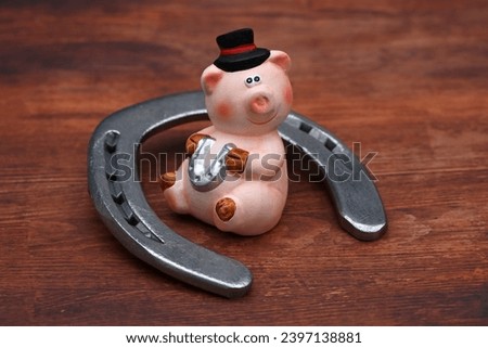 Lucky charm pig and horseshoe. Royalty-Free Stock Photo #2397138881