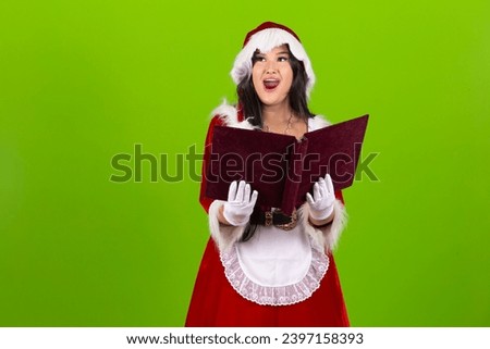 Young woman dressed in Christmas outfit reading Christmas stories in a book