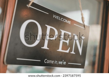 Open sign on a glass door, sign board hanging on glass door in cafe shop open