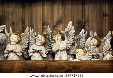 Christmas angels toy with the sparked wings on a wooden wall background. Christmas angel decoration 