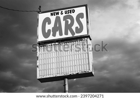 black and white photo of old urban used and new cars sign