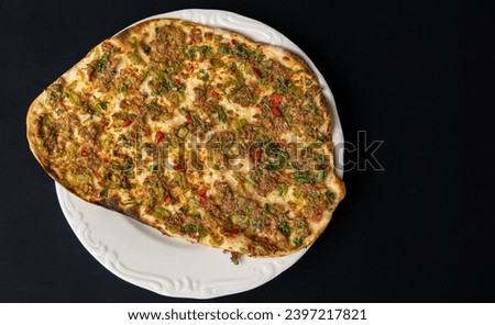 Traditional delicious Turkish foods Home made lahmacun with mince lamb meat on white plate isolated on black background