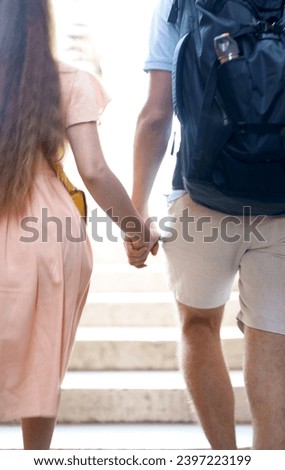 couple holding hands walking through the city