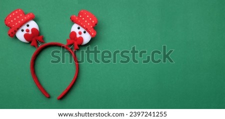 cute Christmas headbands with snowman's isolate on a light green backdrop. concept of joyful Christmas party,New year is coming soon, festive season decoration with Christmas elements