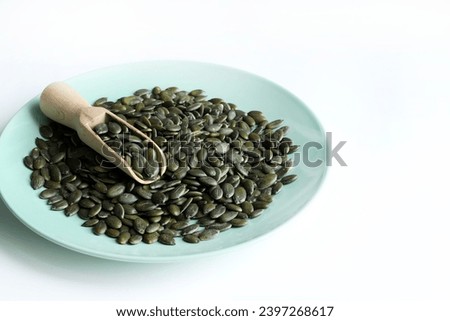 Natural green pumpkin seeds without shell isolated on white background. Healthy food concept. Overhead view. Copy space. Royalty-Free Stock Photo #2397268617