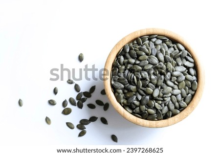 Natural green pumpkin seeds without shell isolated on white background. Healthy food concept. Overhead view. Copy space. Royalty-Free Stock Photo #2397268625