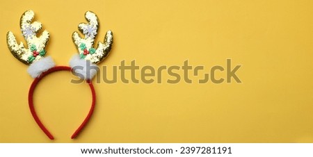 cute Headband Christmas, Christmas deer horns isolate on a yellow backdrop. concept of joyful Christmas party,New year is coming soon, festive season decoration with Christmas elements