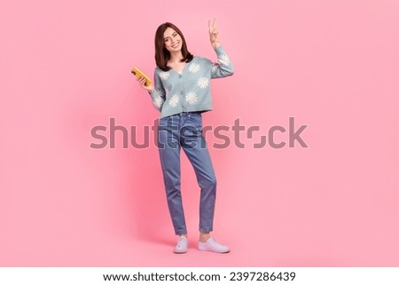 Full body size photo of blogger lady show v sign hold mobile phone gadget wear cardigan jeans shoes isolated pink color background