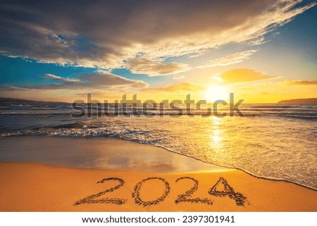 Happy New Year 2024 concept, lettering on the beach. Written text on the sea beach at sunrise.