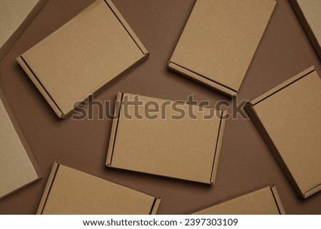 Many closed cardboard boxes on brown background, flat lay Royalty-Free Stock Photo #2397303109