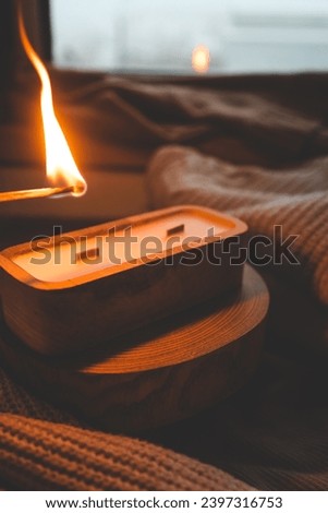 A match lights a candle in wood.