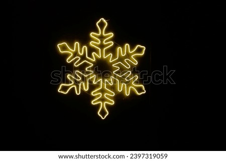 Soft golden Christmas lights within a green shrub with thick snow covering the ground during night