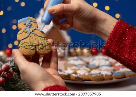 Decorating Christmas gingerbread with sugar multicolored icing.