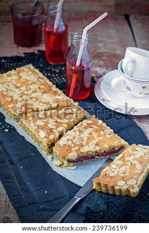 English traditional Bakewell tart with raspberry jam and almonds. Vignetting. Selective focus