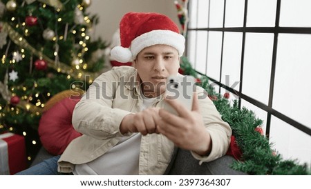 Young hispanic man make selfie by smartphone celebrating christmas at home