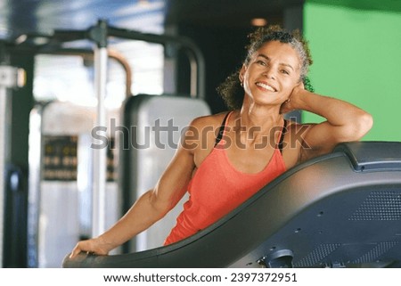 Gym portrait of mature woman leaning on treadmill, active and healthy lifestyle concept Royalty-Free Stock Photo #2397372951