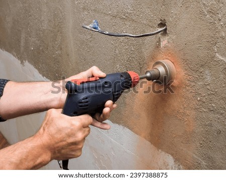 Drilling a socket in a brick wall, a drill for a socket, a worker doing electrical repairs Royalty-Free Stock Photo #2397388875