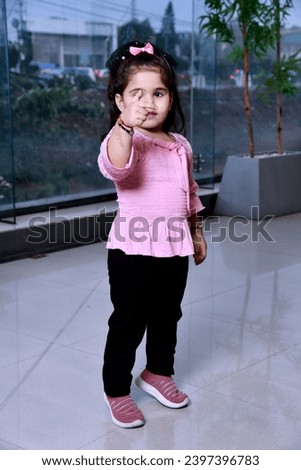 Indian little girl showing thumps up and giving expression