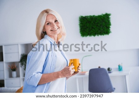Photo portrait of lovely senior lady hold coffee mug working pause relax house interior design cozy living room modern home decor