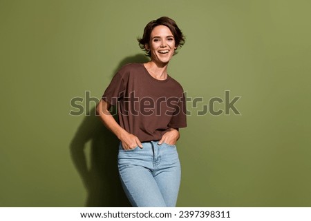 Photo of good mood lovely woman with bob hairstyle dressed brown t-shirt palms in pockets smiling isolated on khaki color background
