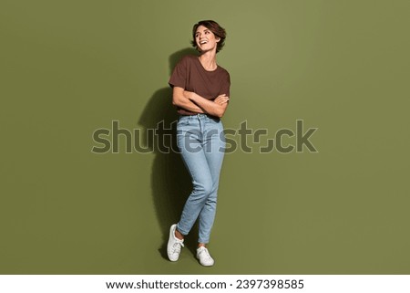 Full size photo of satisfied cute woman dressed brown t-shirt arms crossed look at sale empty space isolated on khaki color background